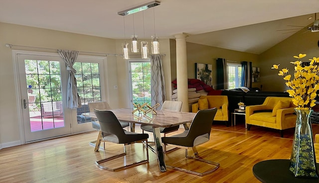 dining area featuring wood-type flooring, plenty of natural light, and ornate columns