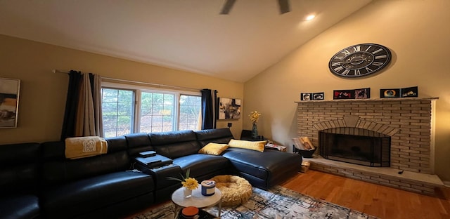 living room with a brick fireplace, hardwood / wood-style floors, and high vaulted ceiling