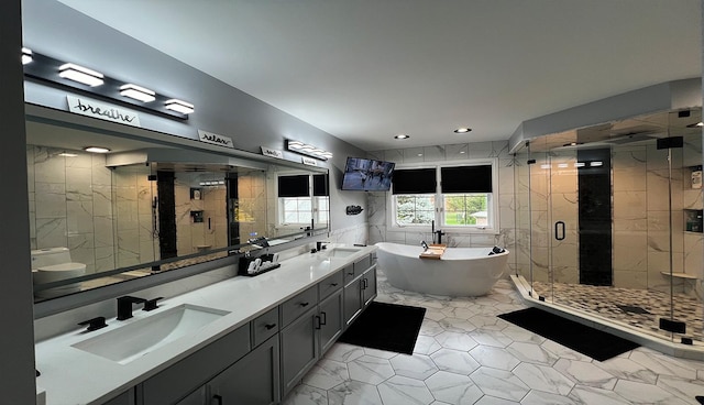 bathroom with vanity, shower with separate bathtub, and tile walls