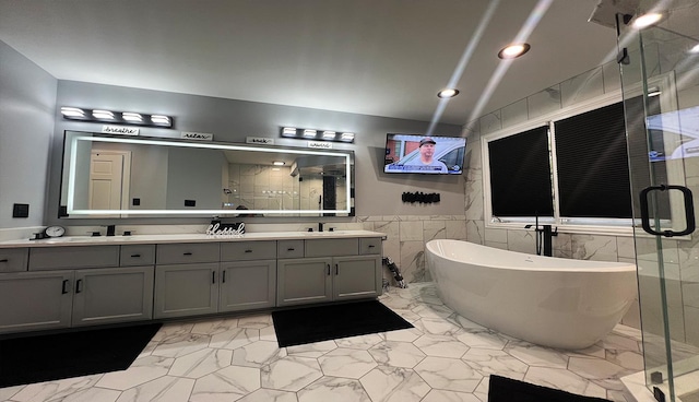 bathroom featuring plus walk in shower, tile walls, and vanity