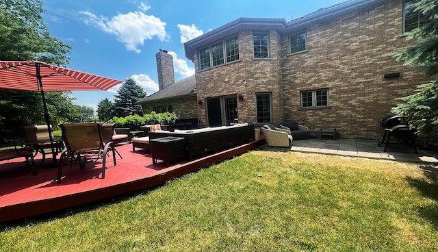 rear view of property with an outdoor living space, a yard, and a deck