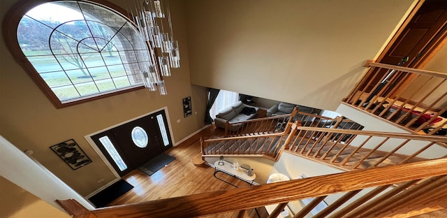 entryway with hardwood / wood-style flooring and a towering ceiling