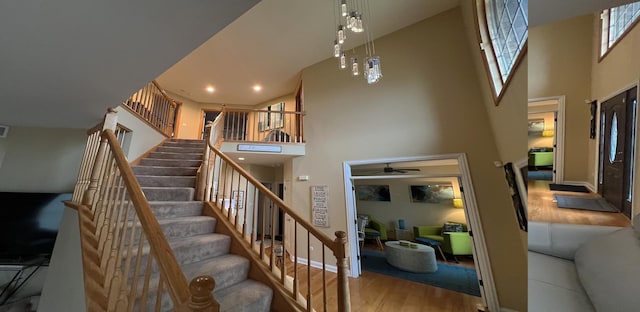 staircase featuring hardwood / wood-style flooring and a towering ceiling