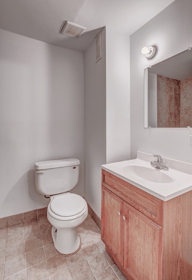 bathroom featuring vanity, tile patterned floors, and toilet