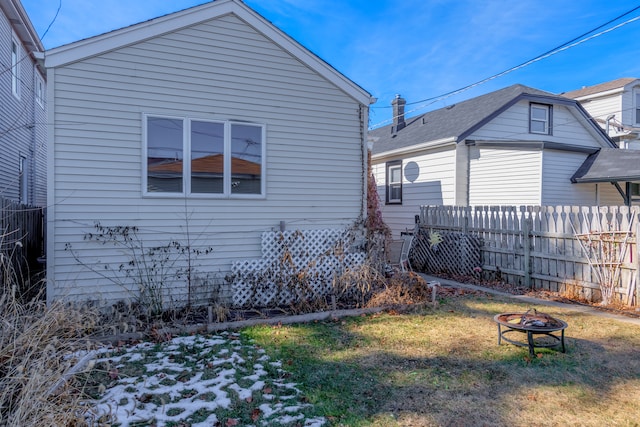 rear view of property with a fire pit