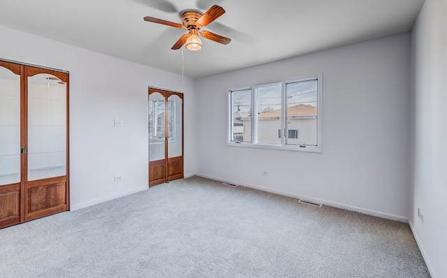 unfurnished bedroom featuring french doors, ceiling fan, and light carpet