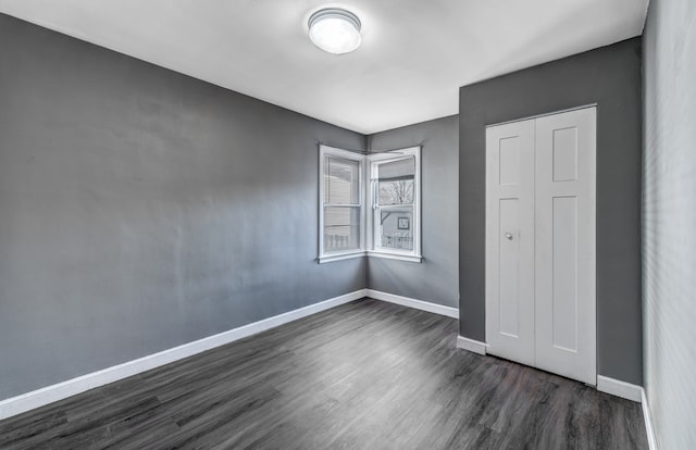 unfurnished bedroom featuring a closet and dark hardwood / wood-style floors