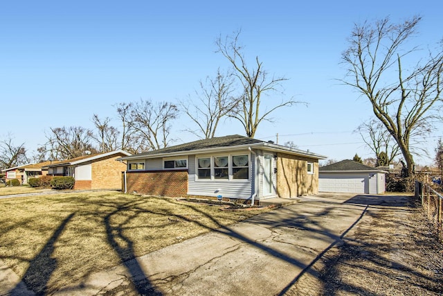 ranch-style home with an outbuilding, a garage, and a front lawn