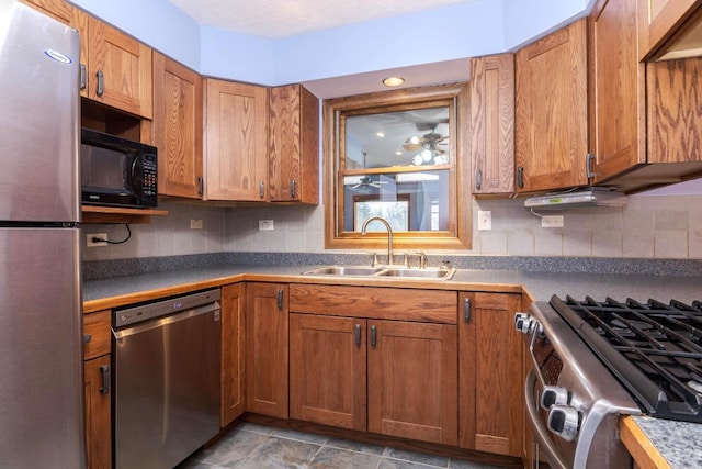 kitchen with ceiling fan, stainless steel appliances, sink, and decorative backsplash