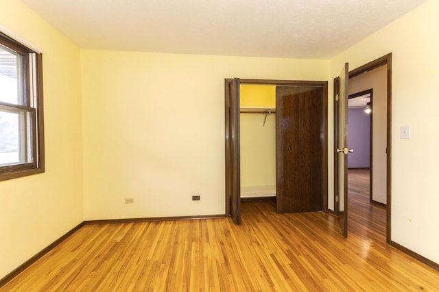 unfurnished bedroom with a closet and light wood-type flooring