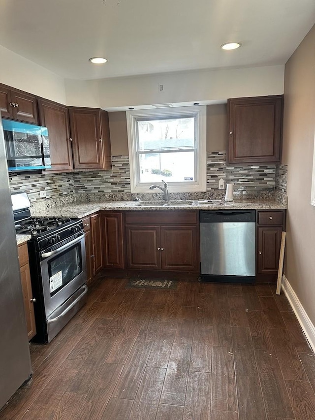 kitchen featuring light stone counters, sink, dark wood-type flooring, and appliances with stainless steel finishes