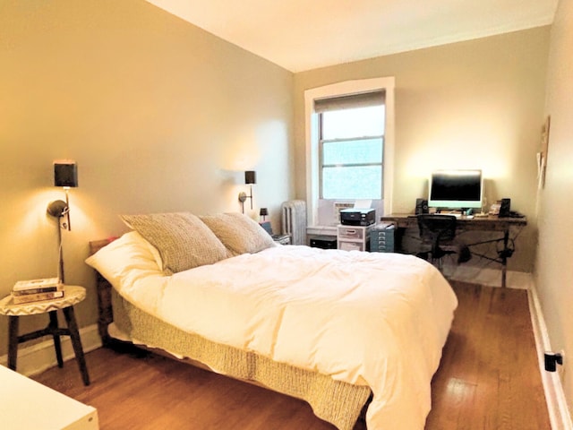 bedroom featuring dark hardwood / wood-style flooring and radiator