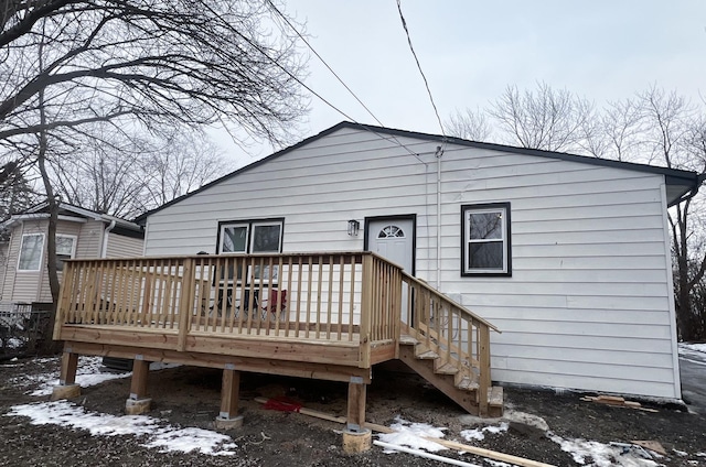 snow covered house featuring a wooden deck