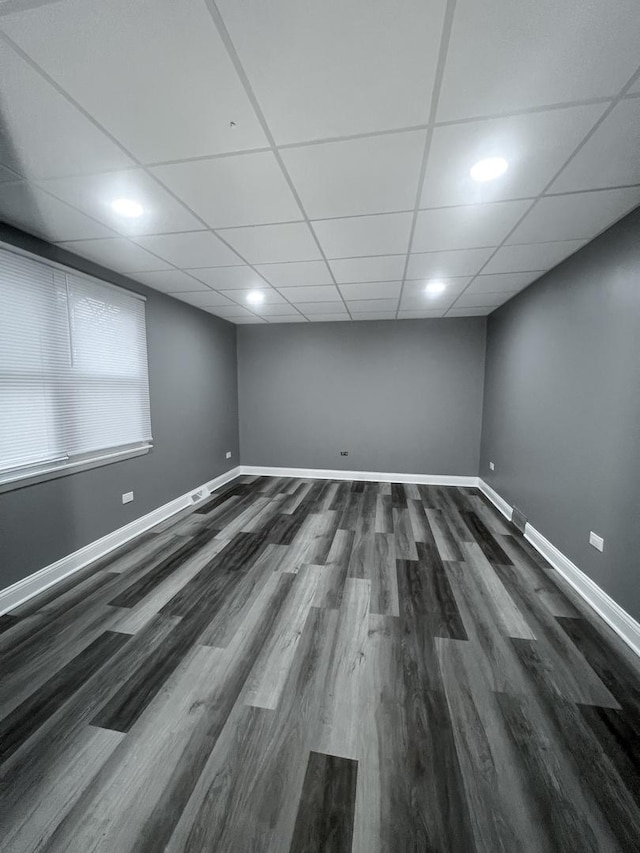 spare room featuring dark hardwood / wood-style floors and a paneled ceiling