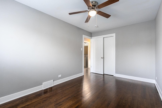 unfurnished bedroom featuring a closet, dark hardwood / wood-style floors, and ceiling fan