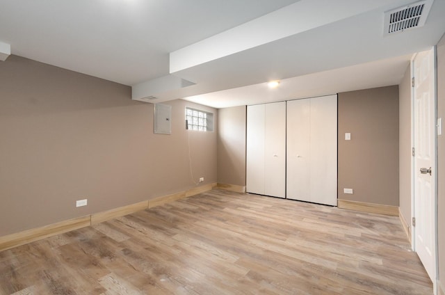 basement with electric panel and light wood-type flooring