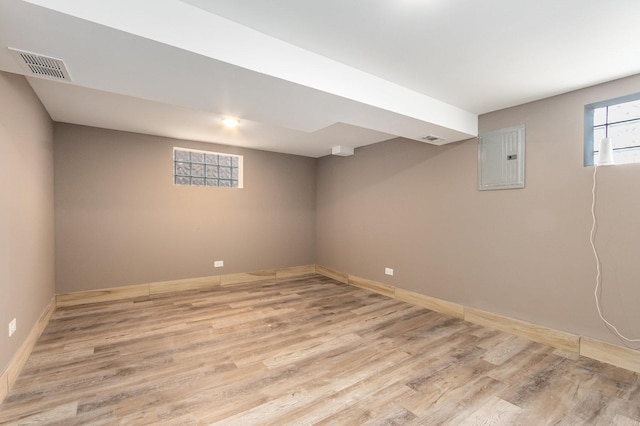 basement with electric panel and light hardwood / wood-style flooring