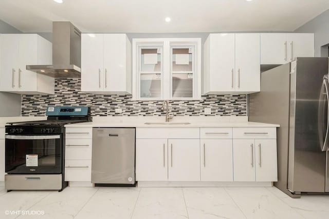 kitchen featuring sink, wall chimney range hood, stainless steel appliances, decorative backsplash, and white cabinets