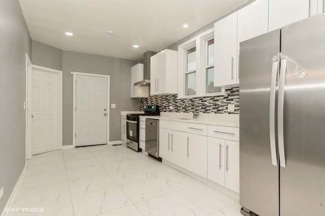 kitchen featuring tasteful backsplash, stainless steel appliances, wall chimney exhaust hood, and white cabinets