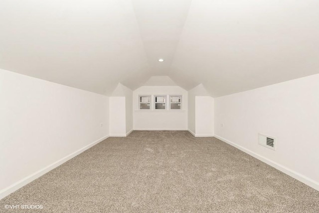 bonus room with vaulted ceiling and carpet