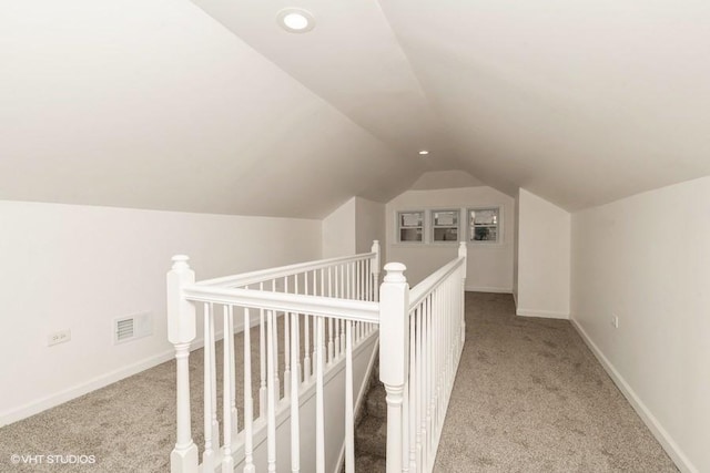 interior space featuring light colored carpet and vaulted ceiling