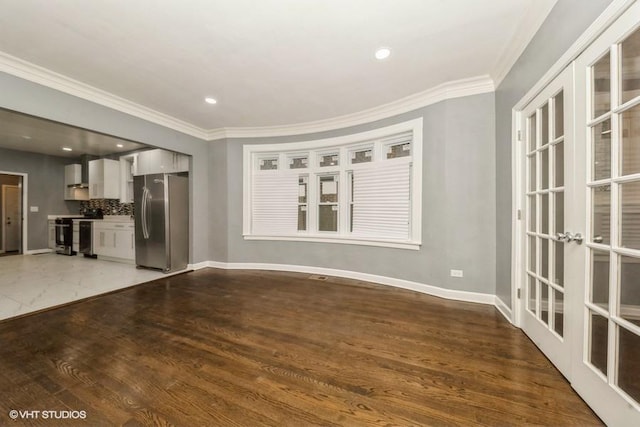 unfurnished living room featuring ornamental molding, wood-type flooring, and french doors