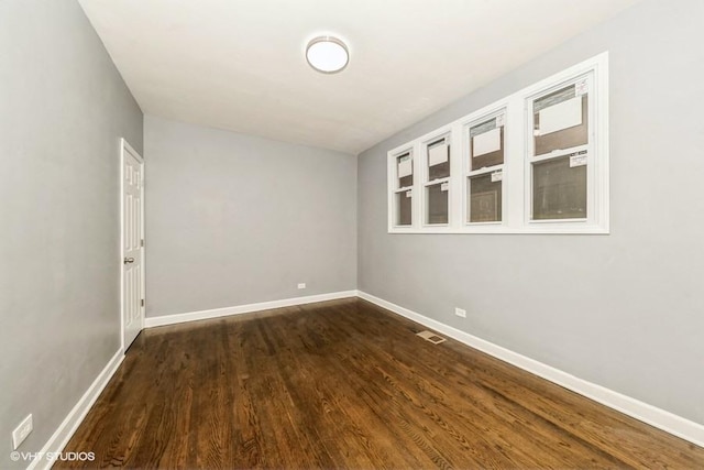 spare room with dark wood-type flooring