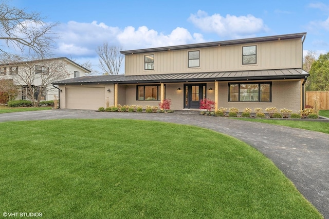 view of front facade with a garage, a porch, and a front lawn