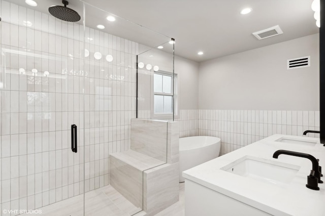 bathroom with tile walls, sink, and shower with separate bathtub