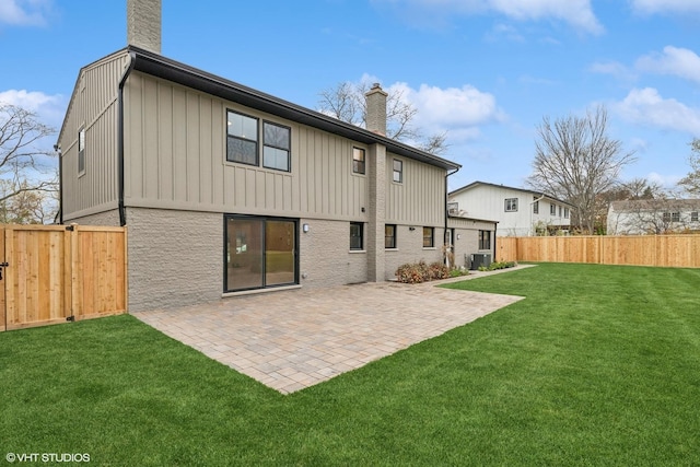 rear view of house with a patio and a lawn