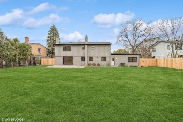 rear view of property featuring a patio and a lawn