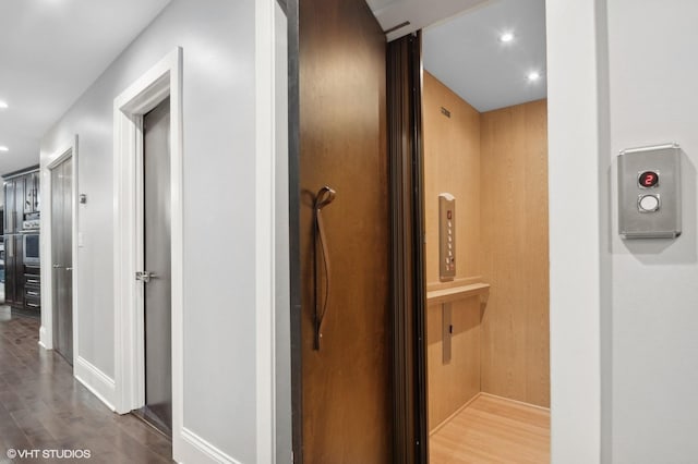 corridor featuring hardwood / wood-style flooring and elevator