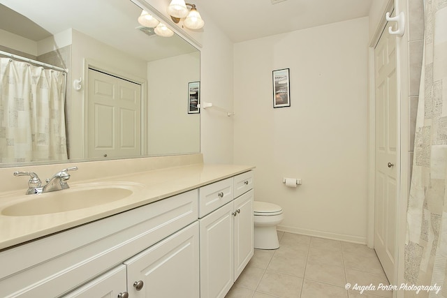 bathroom featuring vanity, tile patterned floors, and toilet