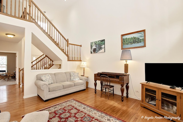 living room featuring wood-type flooring and a high ceiling