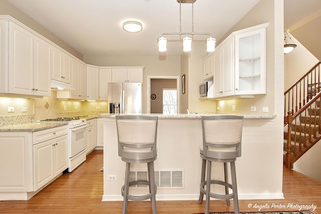 kitchen with white cabinetry, stainless steel appliances, and a kitchen breakfast bar