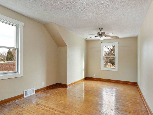 bonus room featuring ceiling fan, light hardwood / wood-style floors, and a textured ceiling