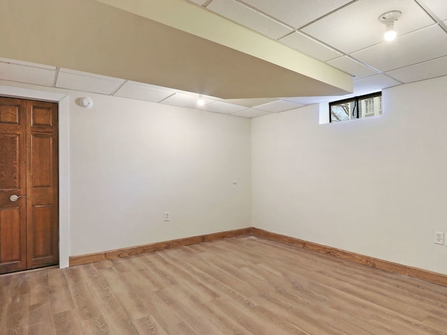 basement featuring light hardwood / wood-style flooring and a drop ceiling