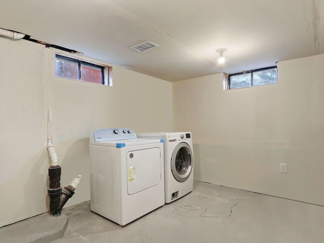 clothes washing area with independent washer and dryer and a wealth of natural light