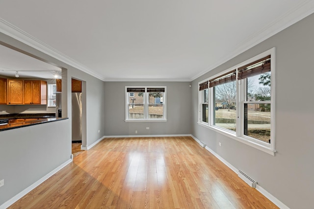 unfurnished living room with a baseboard heating unit, crown molding, and light hardwood / wood-style floors