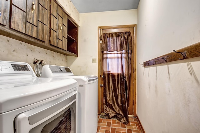 washroom featuring brick floor, cabinet space, and separate washer and dryer