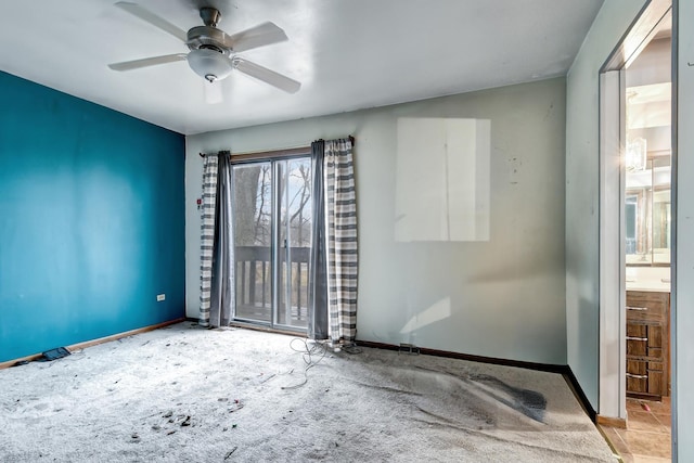 unfurnished room with ceiling fan and baseboards