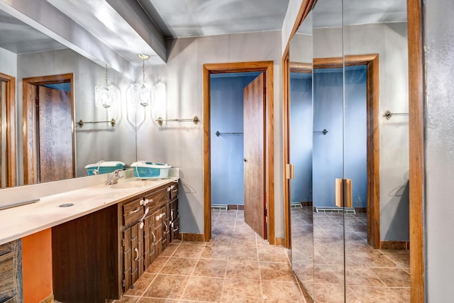 bathroom with vanity, baseboards, and tile patterned floors