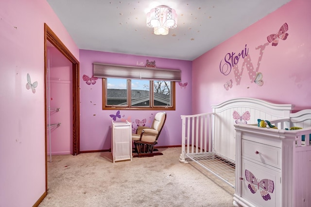 bedroom with a crib, carpet flooring, and baseboards