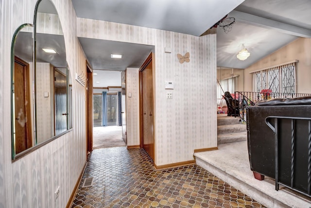 hall featuring wallpapered walls, vaulted ceiling with beams, baseboards, and visible vents