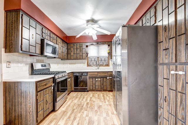 kitchen featuring light wood finished floors, tasteful backsplash, ceiling fan, stainless steel appliances, and light countertops