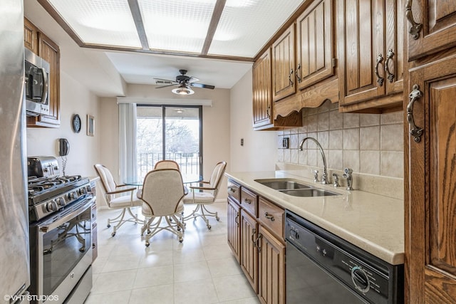 kitchen with sink, light tile patterned floors, ceiling fan, appliances with stainless steel finishes, and tasteful backsplash