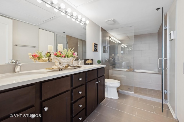 bathroom featuring a shower with door, vanity, tile patterned floors, and toilet