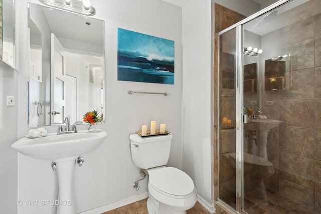 bathroom featuring toilet and a shower with door