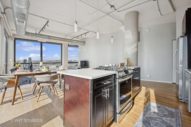 kitchen with track lighting, a kitchen island, light hardwood / wood-style floors, and appliances with stainless steel finishes