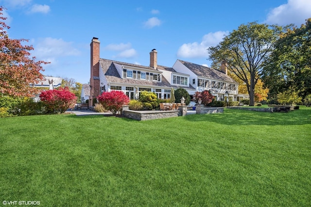 rear view of house featuring a lawn